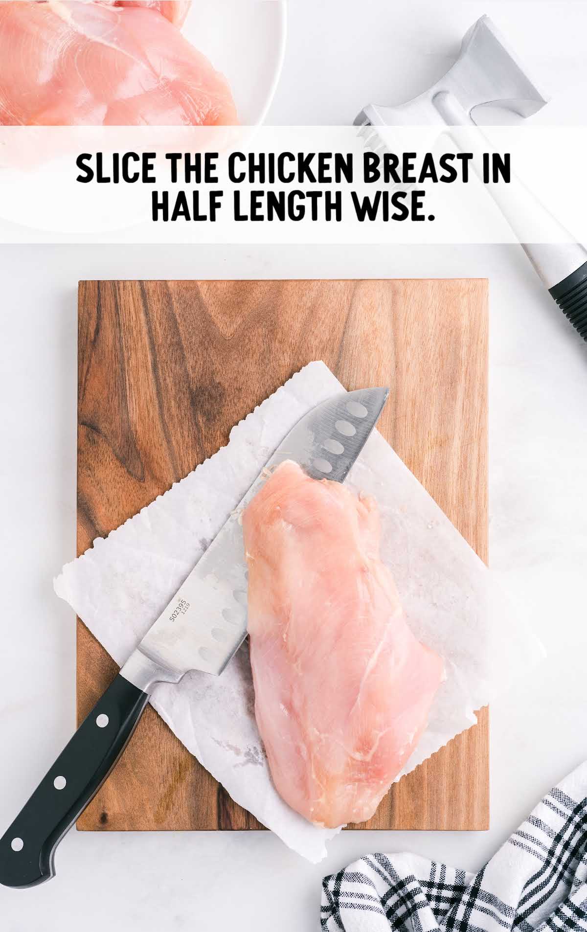chicken breast being sliced on a wooden board
