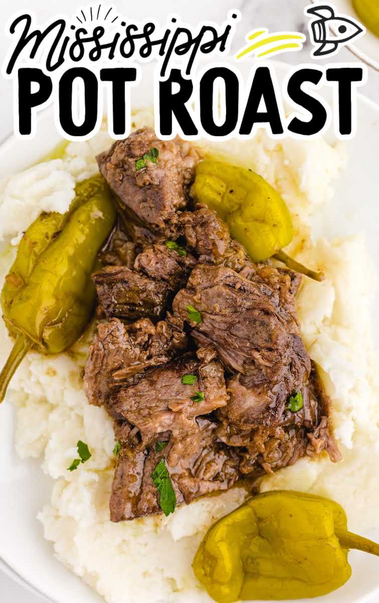 close up shot of Mississippi Pot Roast with pepperoncinis and garnished with parsley served over mashed potatoes on a plate