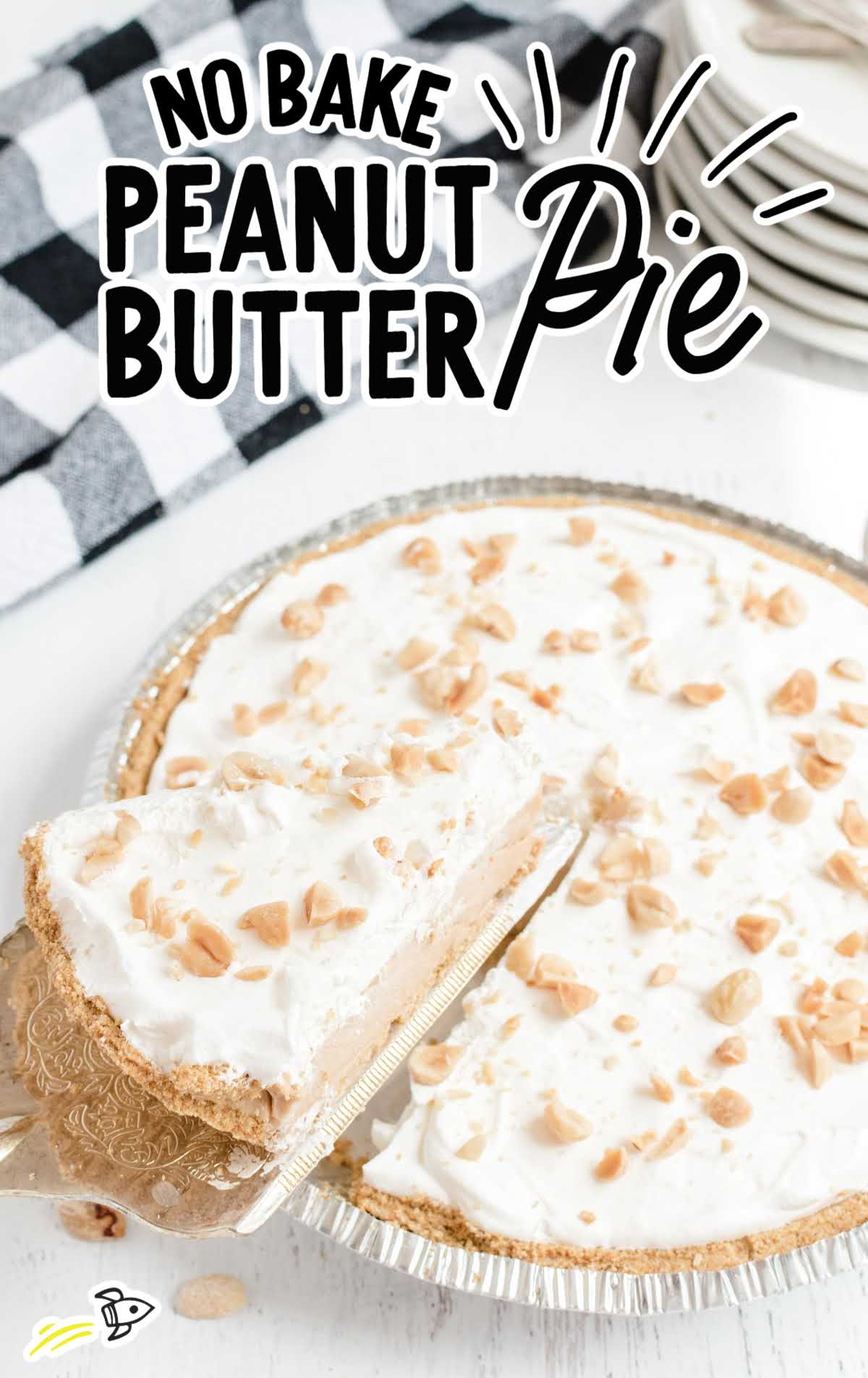 close up shot of No Bake Peanut Butter Pie topped with whipped cream and chopped peanuts with a slice being taken out of it