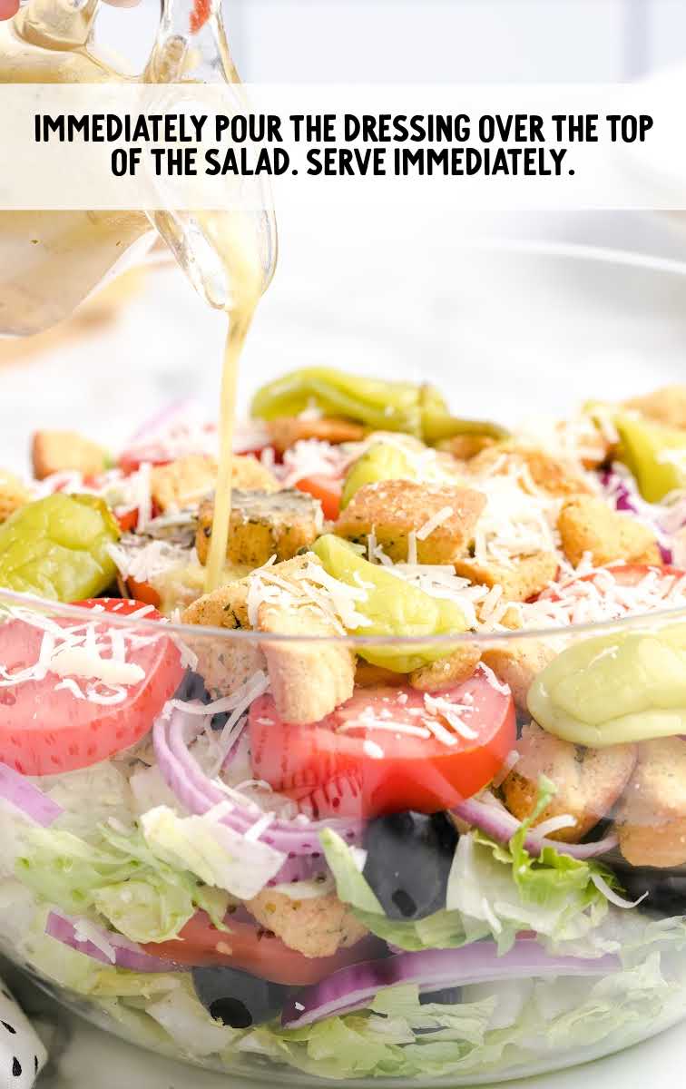 Olive Garden Salad Recipe process shot of salad dressing being poured over salad