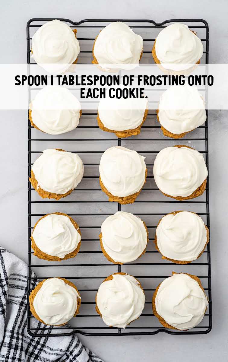 frosting spooned onto each cookie on a baking sheet