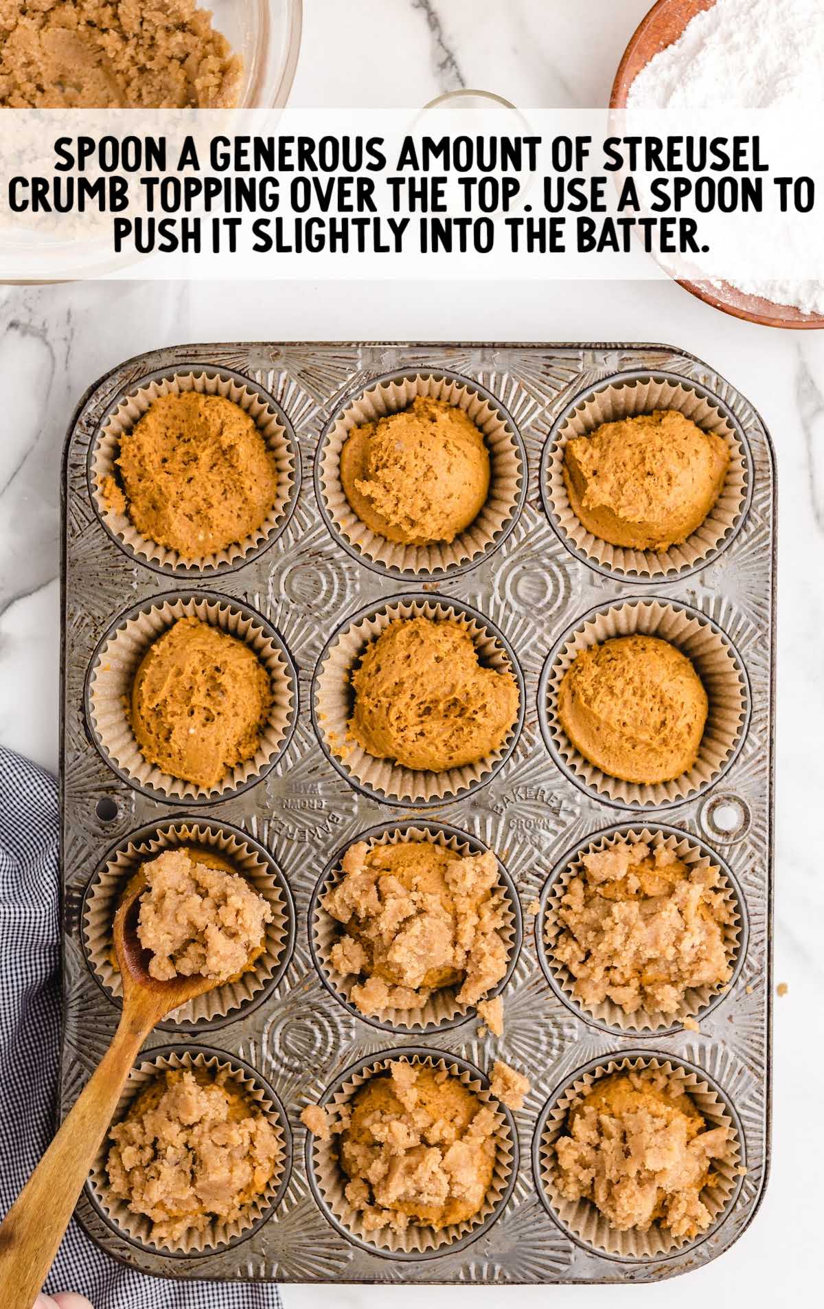 streusel crumb topping spooned over batter in a muffin pan