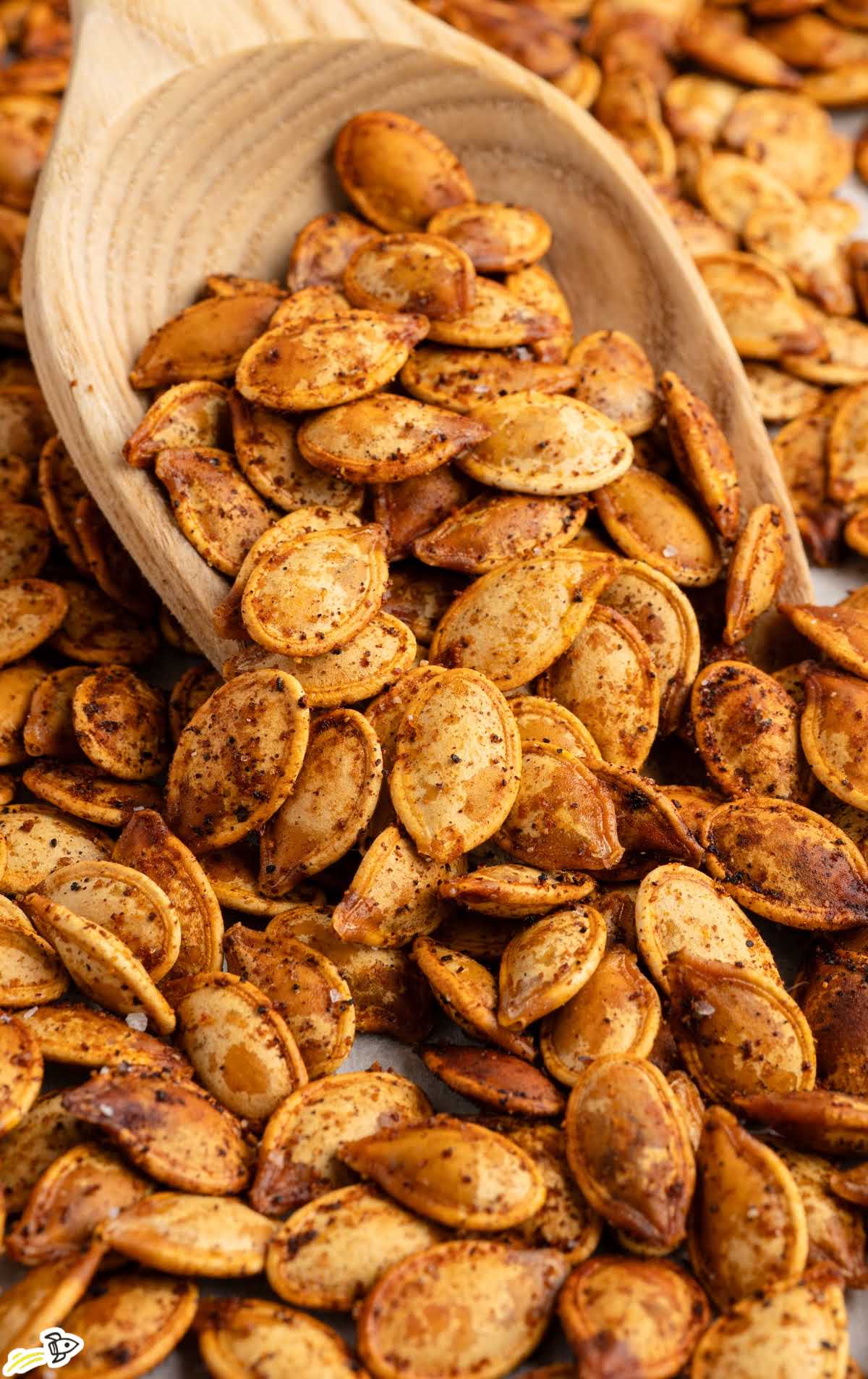 Close-up of crispy roasted pumpkin seeds with a wooden scoop