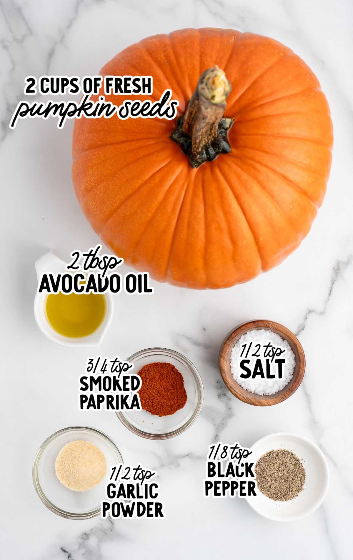 Ingredients for roasted pumpkin seeds including fresh pumpkin seeds, avocado oil, salt, smoked paprika, garlic powder, and black pepper