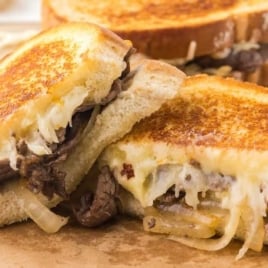 close up shot of a Steak Grilled Cheese sandwich on a wooden board