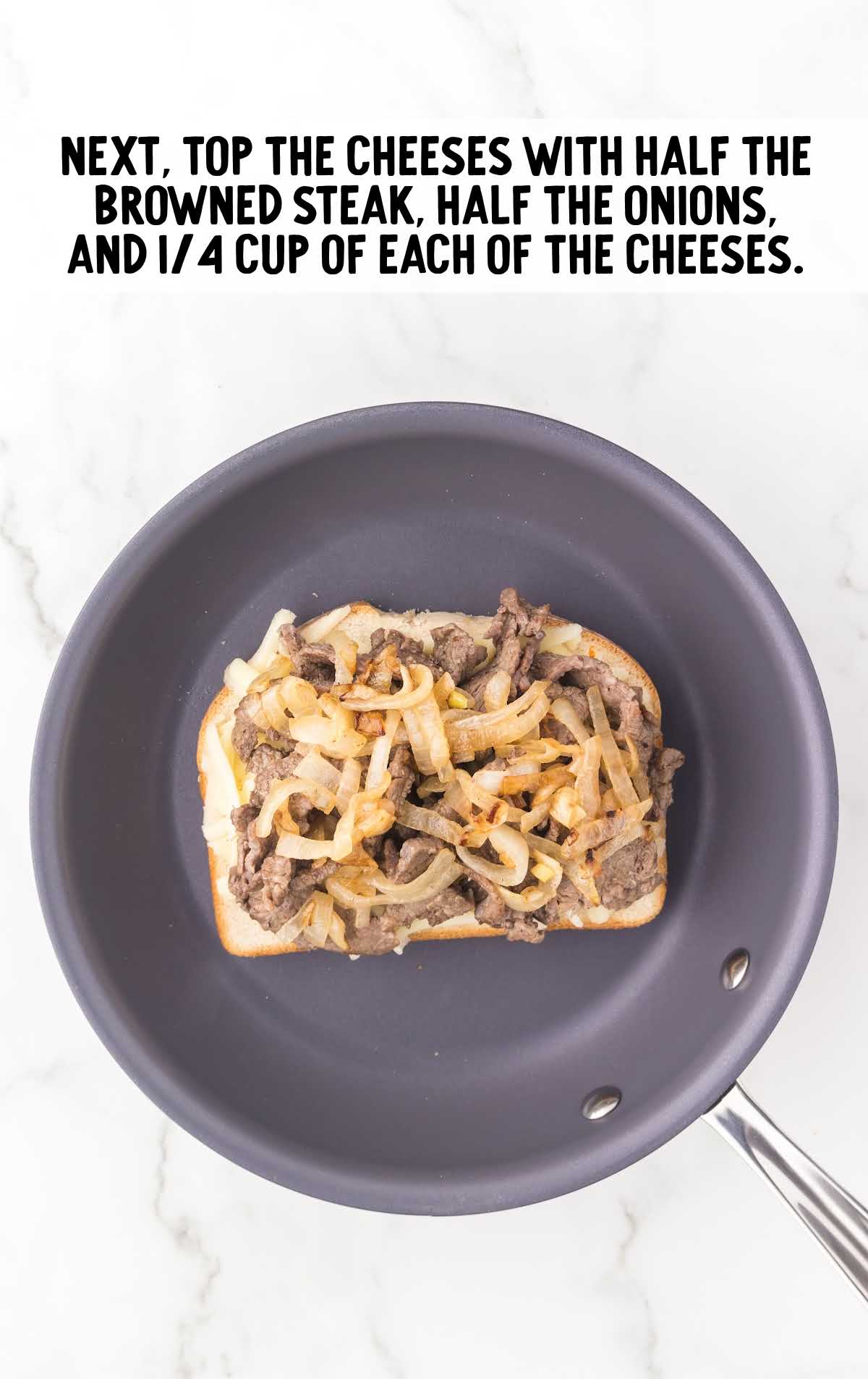cheese topped with browned steak, onions, and cheeses on a skillet