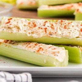 close up shot of Stuffed Celery topped with smoked paprika piled on a plate