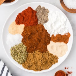 Ingredients for taco seasoning on a white plate.