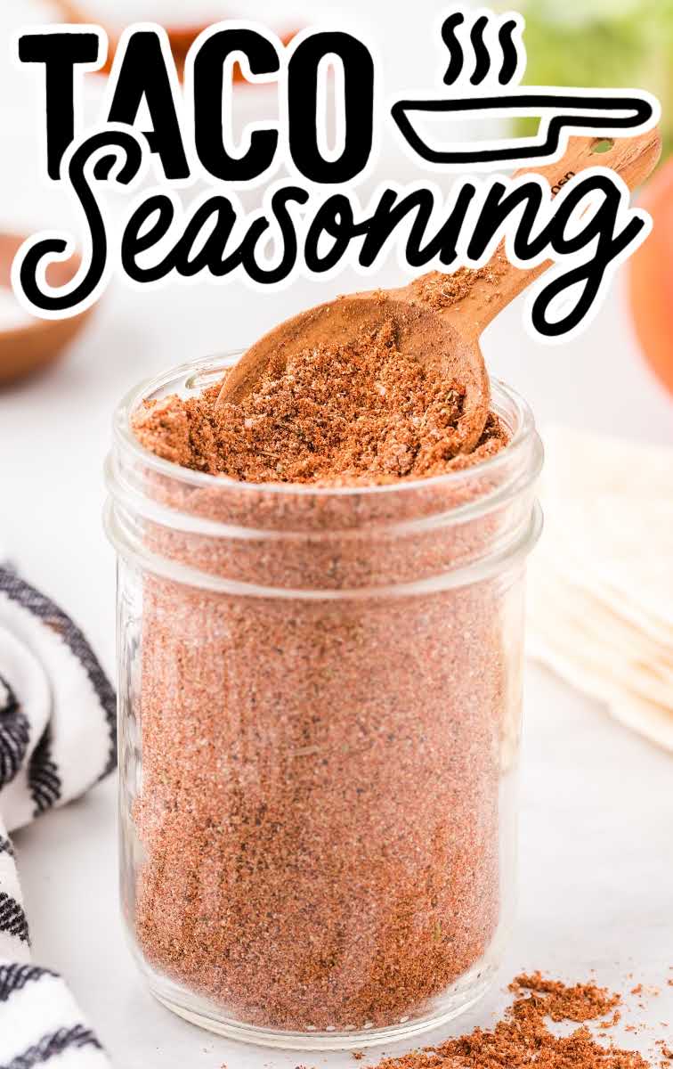 close up shot of a mason jar filled with Taco Seasoning with a wooden spoon