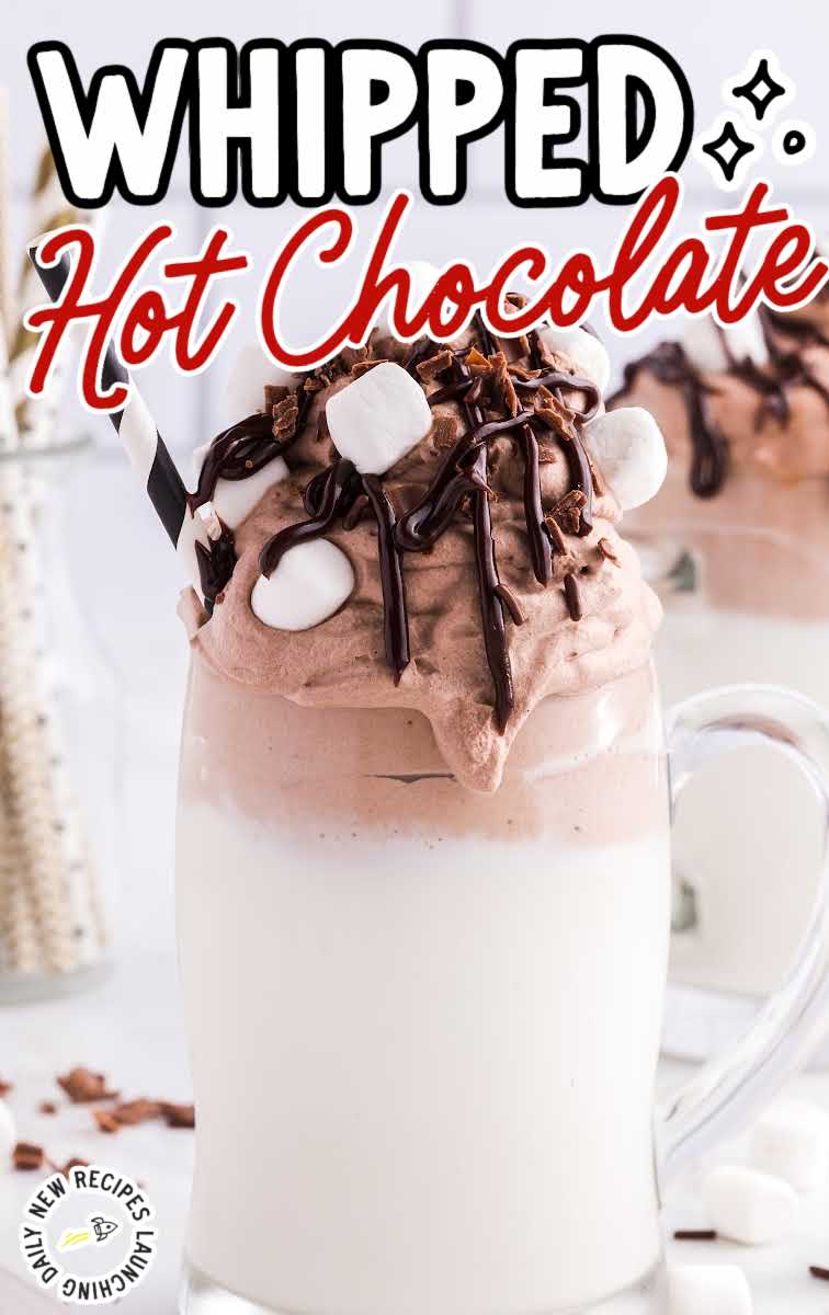 close up shot of a glass of Whipped Hot Chocolate Recipe topped with mini marshmallows and chocolate syrup with a straw