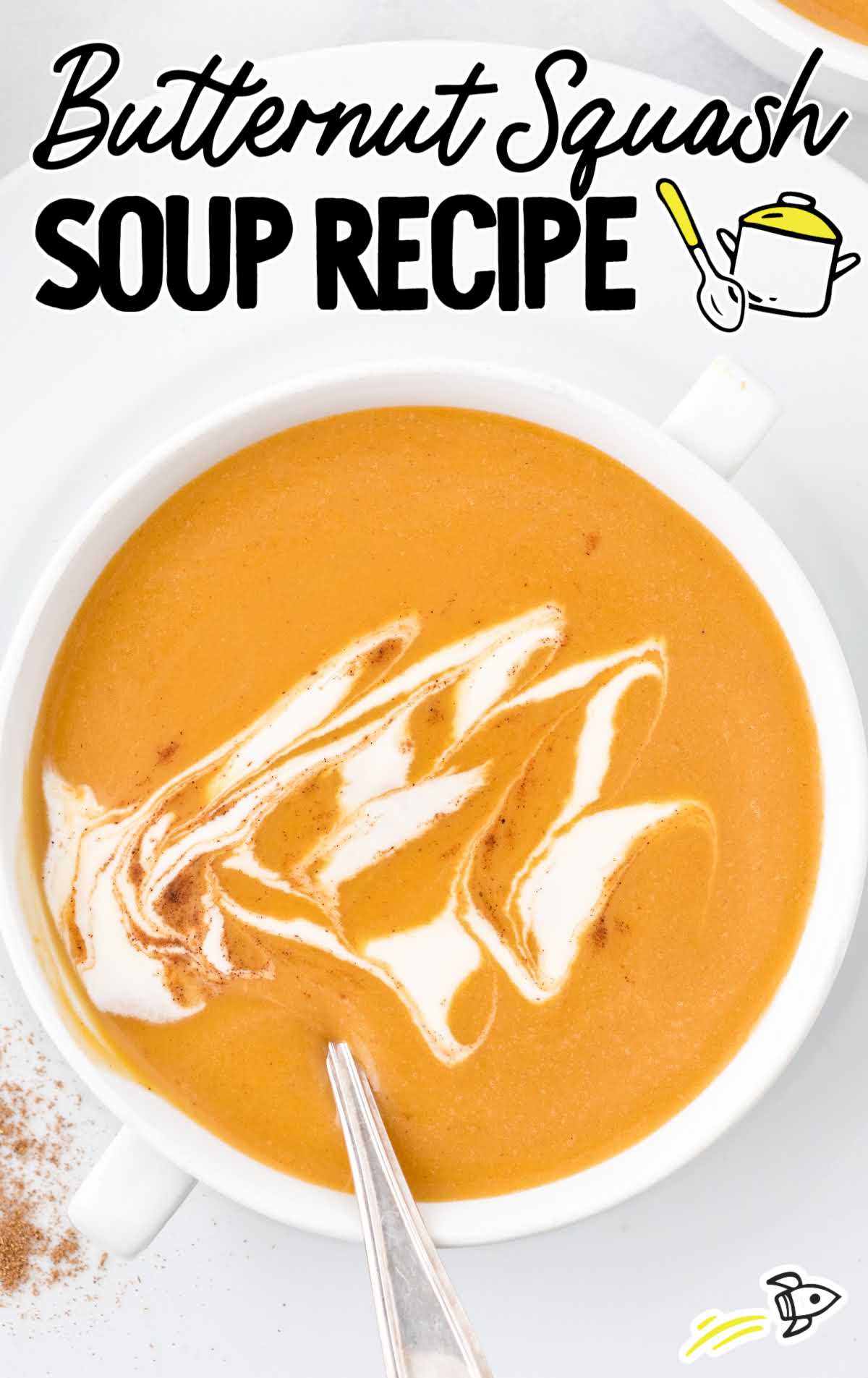 close up overhead shot of butternut squash soup in a soup bowl topped with whipped cream and pumpkin pie spice