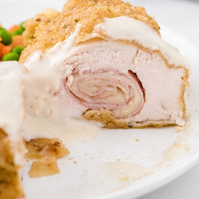 close up shot of a piece of chicken cordon bleu on a plate