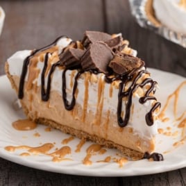 Close-up slice of no bake peanut butter pie with graham cracker crust, whipped topping, and peanut butter drizzle for recipe card.