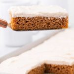 close up shot of a slice of pumpkin sheet cake with icing on a spatula
