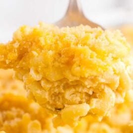 close up shot of Baked Mac and Cheese being grabbed from a baking dish with a large spoon