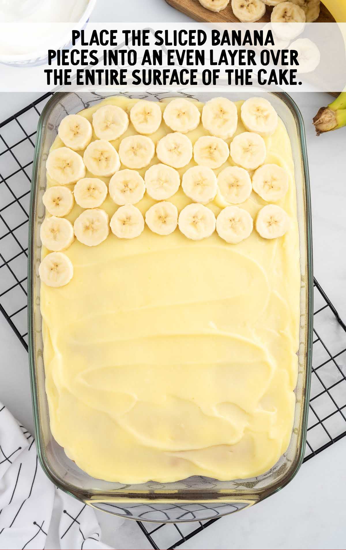 Banana Pudding Cake process shot of banana slices spread over cake