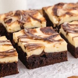 close up shot of Cheesecake Brownies on a wooden board