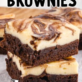 close up shot of Cheesecake Brownies stacked on top of each other on a wooden board