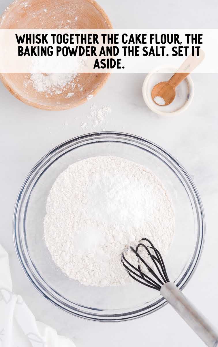 cake flour, baking powder, and salt being whisked together in a bowl