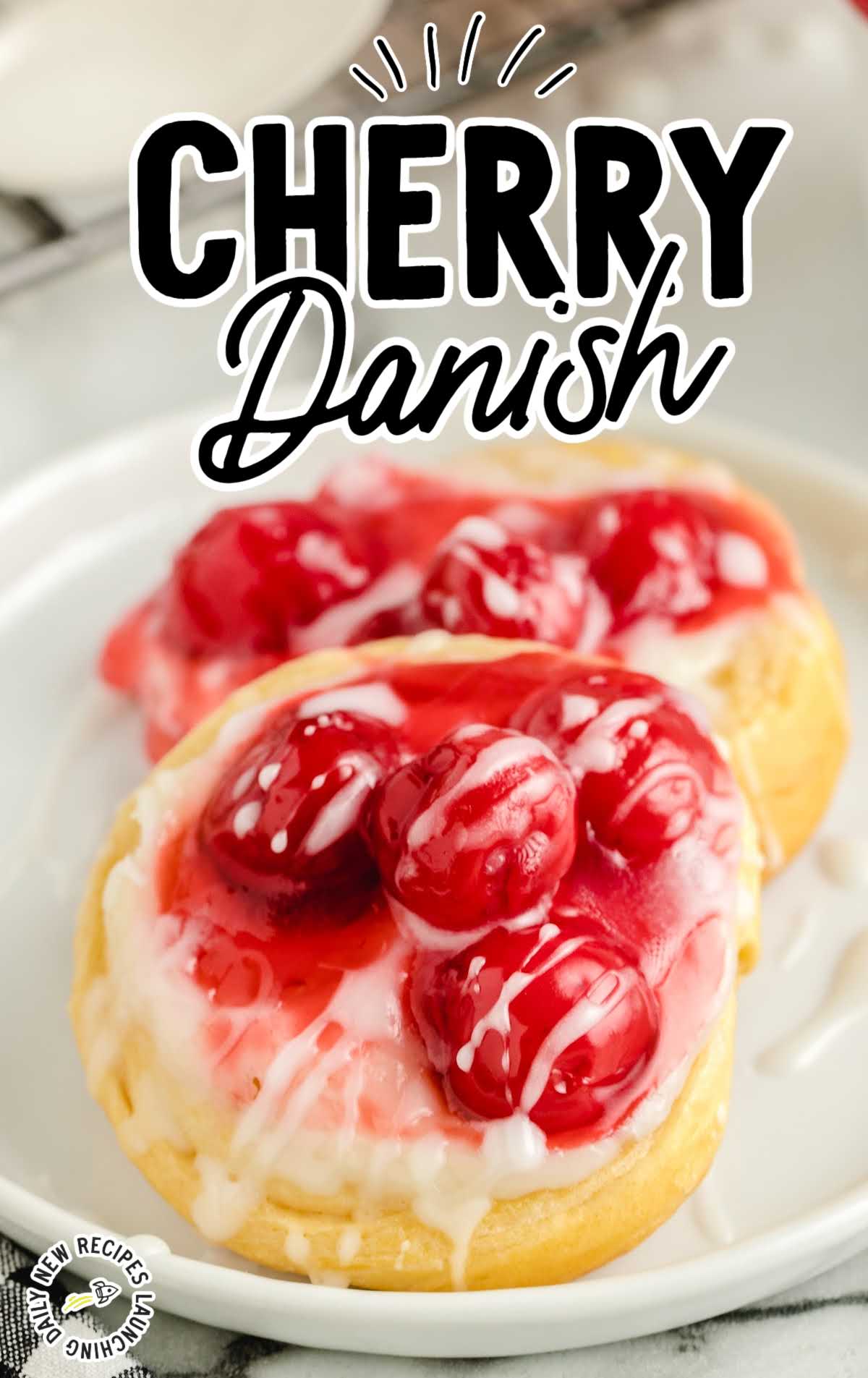 cherry danish topped with glaze on a plate