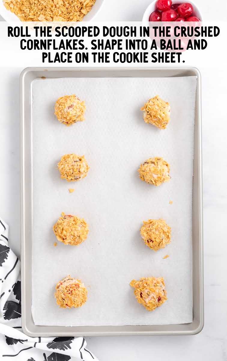 scooped dough rolled into crushed cornflakes and then placed on a cookie sheet
