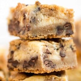 close up shot of Chocolate Chip Cheesecake Bars stacked on top of each other