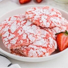 close up shot of a plate of Cool Whip Cookies with a slice of strawberry