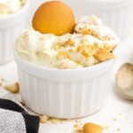 close up shot of a small bowl of copycat magnolia banana pudding topped with a vanilla wafers