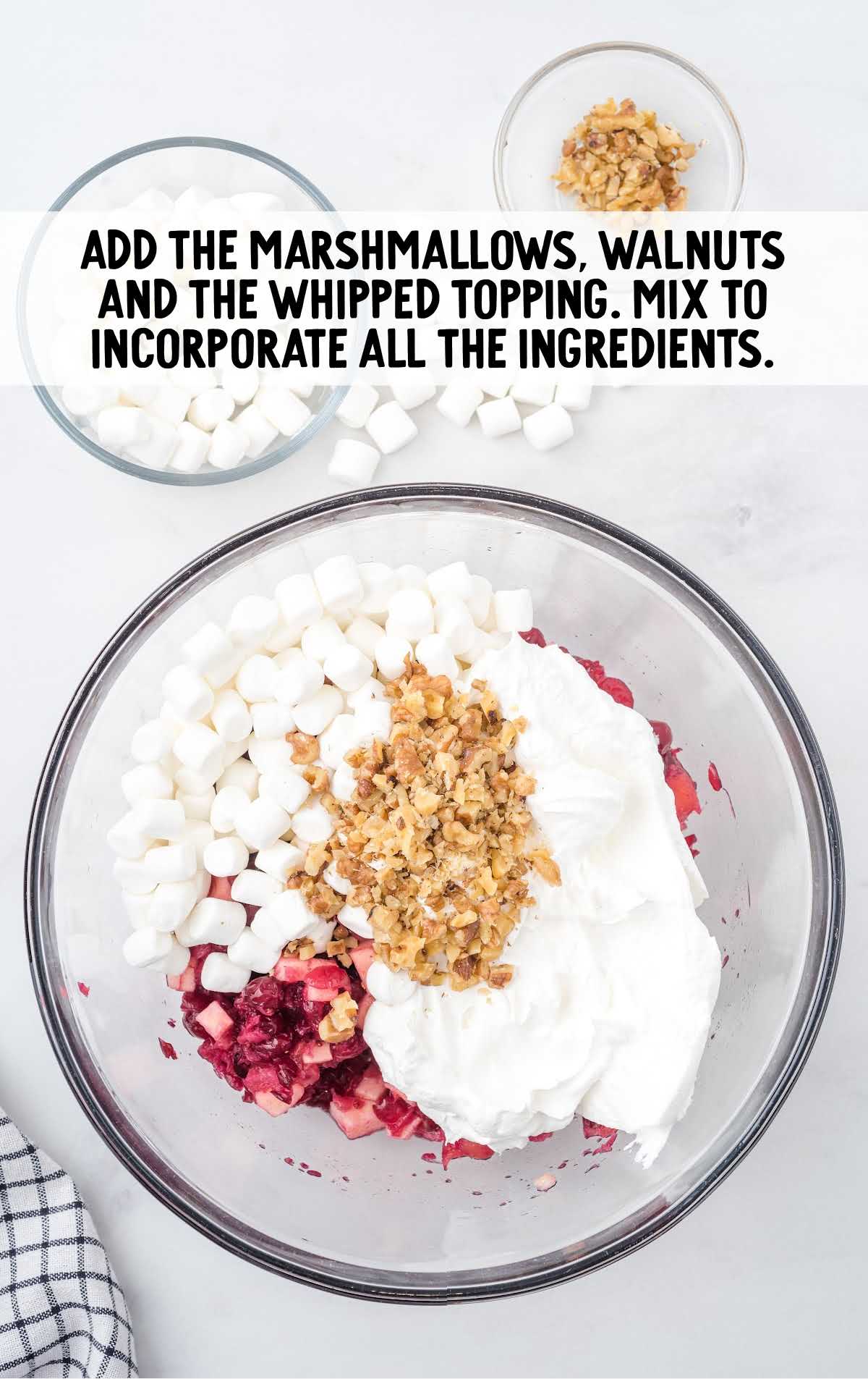marshmallows, walnuts, and whipped topping added to the cranberry mixture in the bowl