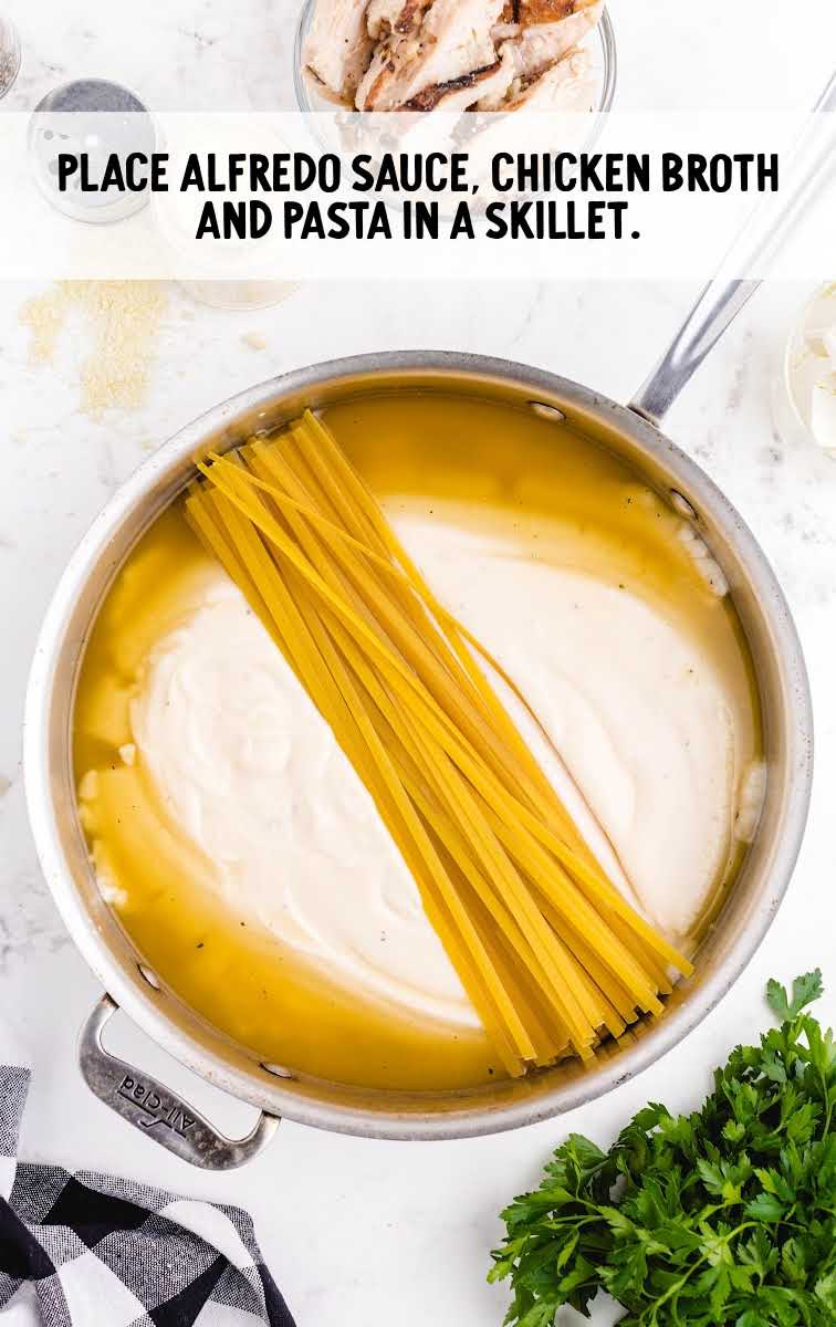 alfredo sauce, chicken broth and pasta added to a skillet