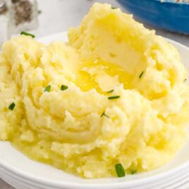close up shot of a plate of Creamy Mashed Potatoes garnished with chives