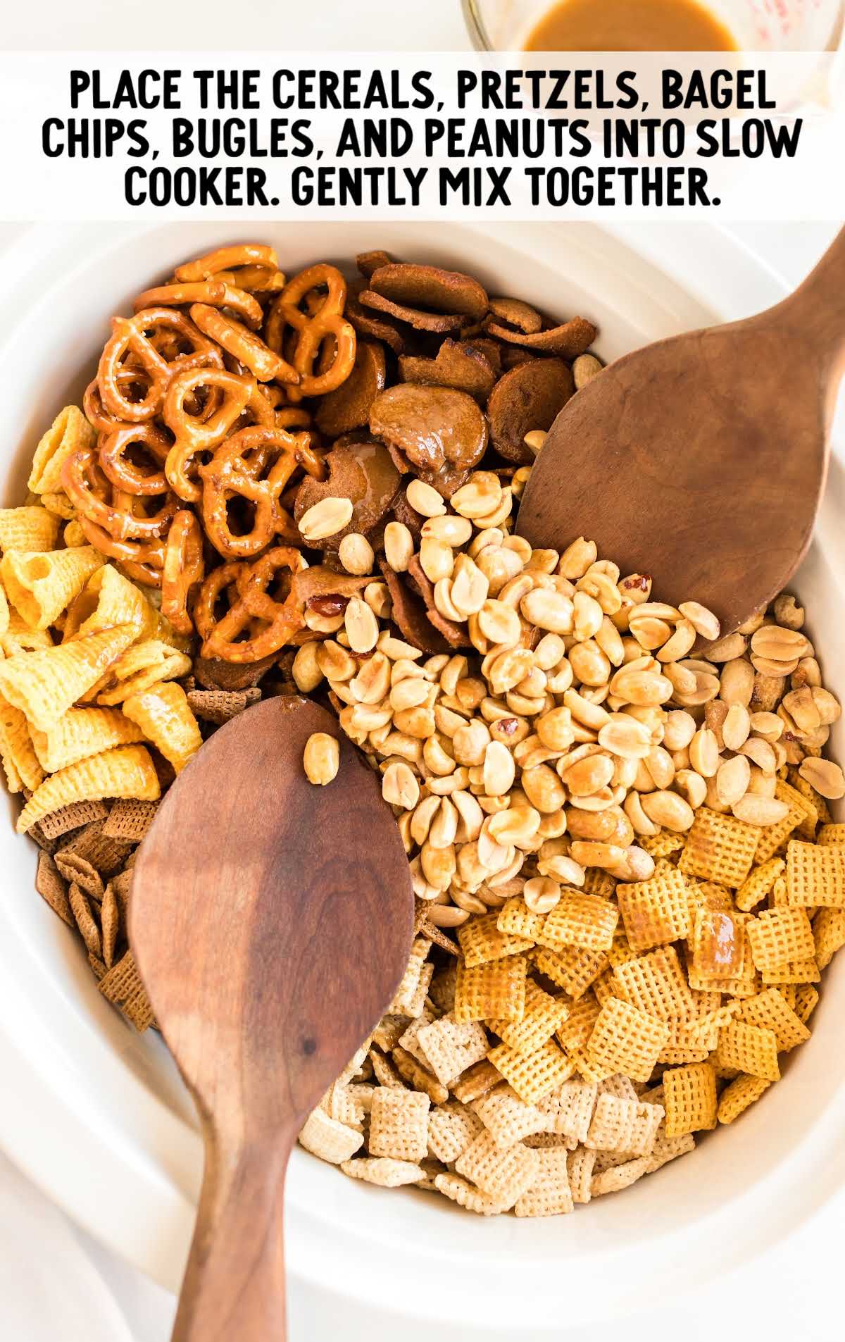 cereal, pretzel, bagel chips, bugles, and peanuts placed in a slow cooker
