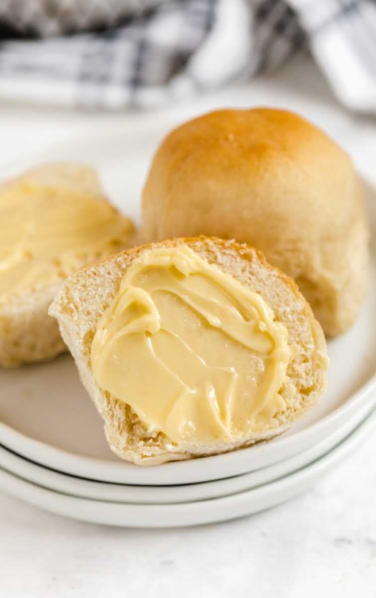close up shot of Dinner Rolls spread with butter on a plate