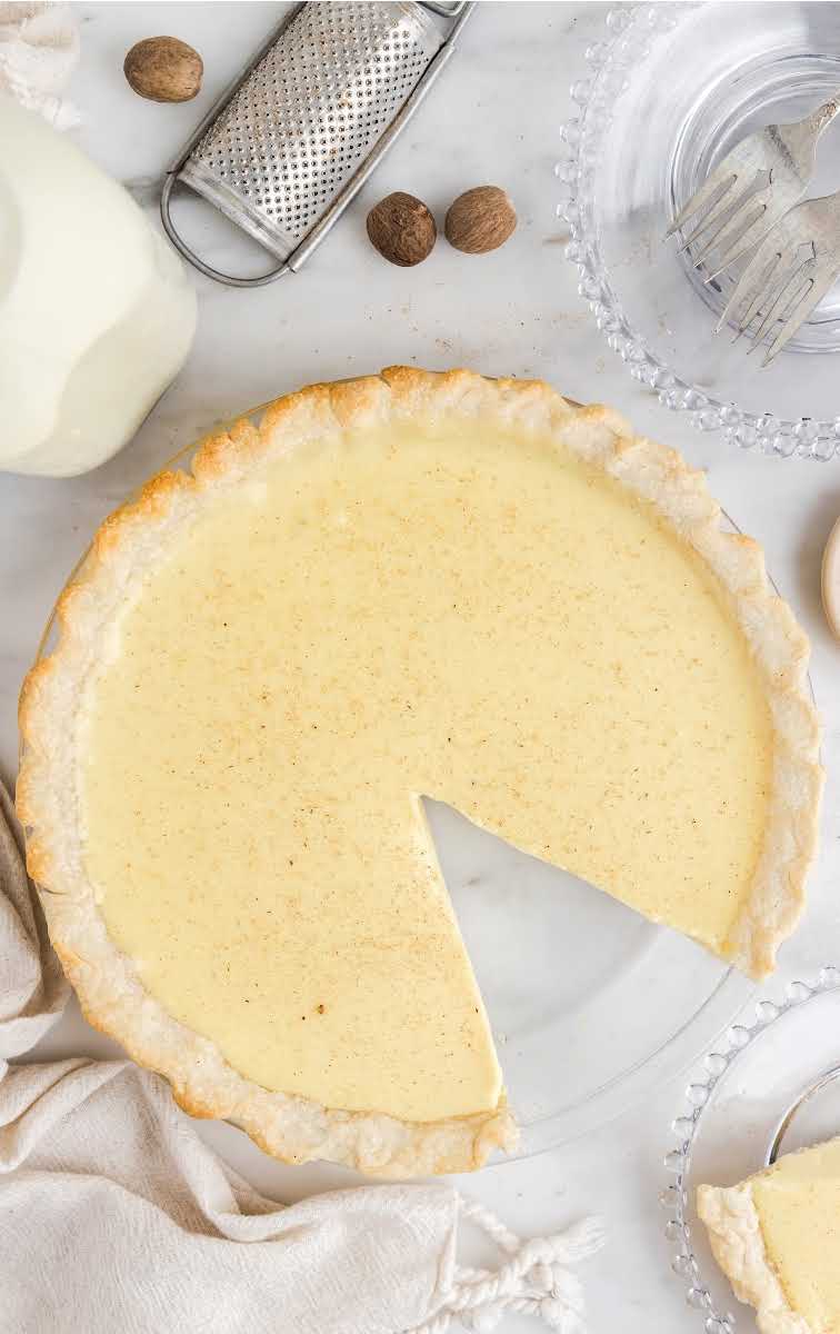 close up overhead shot of eggnog pie sprinkled with nutmeg with a slice missing