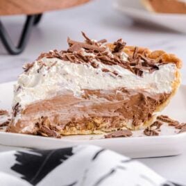 close up shot of a slice of french silk pie garnished with chopped chocolate on a plate