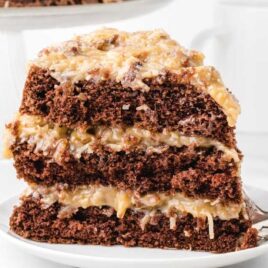 close up shot of a slice of German Chocolate Cake with coconut pecan frosting on a plate