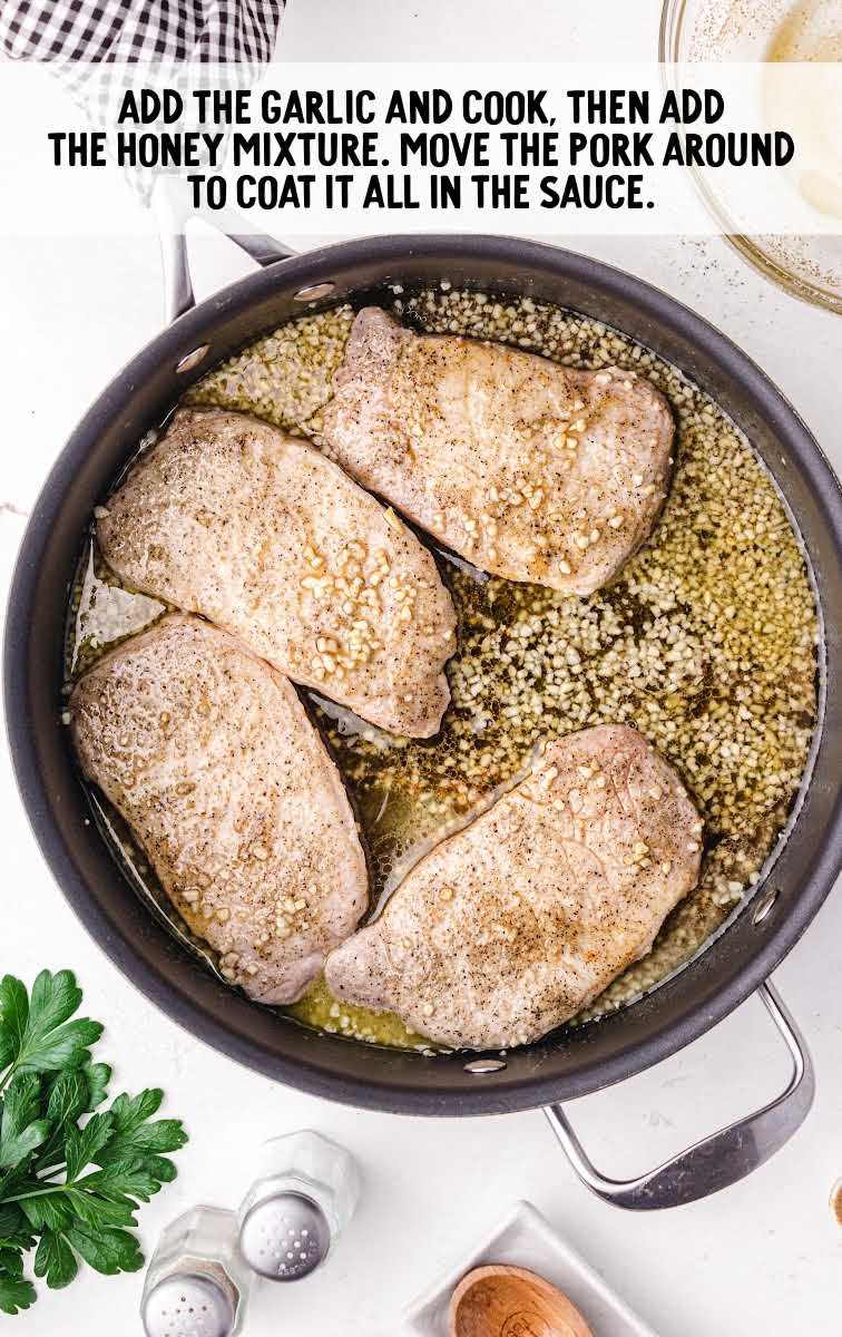 garlic and pork chops added to a skillet