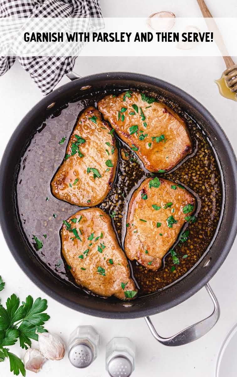 pork chops garnished with parsley in a skillet