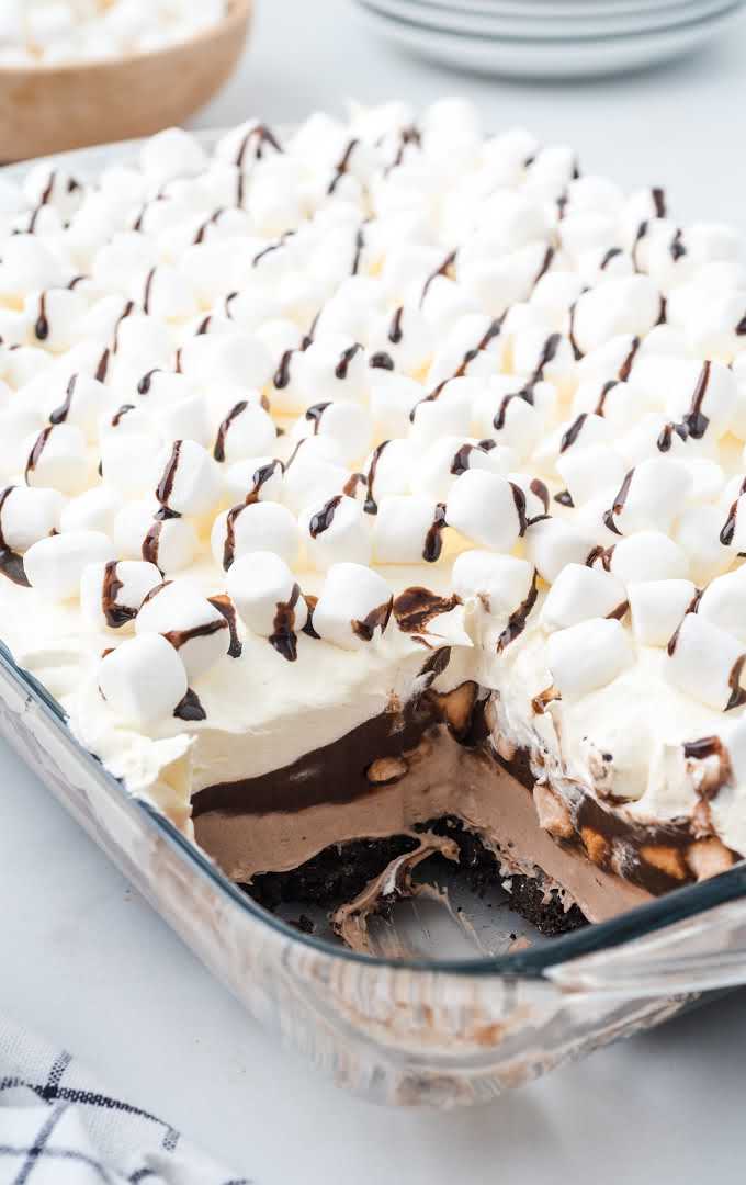 close up shot of Hot Chocolate Lasagna topped with mini marshmallows and drizzled with chocolate syrup in a baking dish