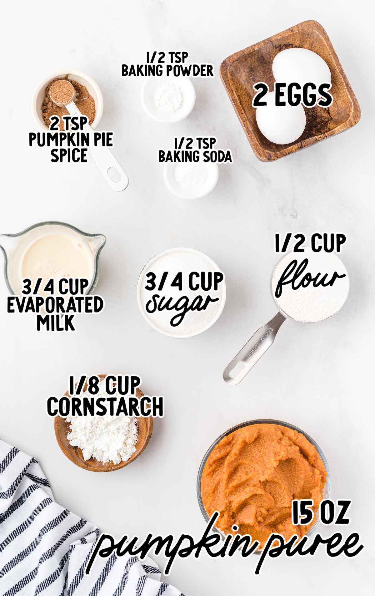 Overhead photo of measured ingredients for pumpkin pie cupcakes including pumpkin puree, eggs, sugar, evaporated milk, flour, cornstarch, baking soda, baking powder, and pumpkin pie spice.