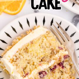 close up overhead shot of a slice of Orange Cranberry Cake garnished with chopped walnuts on a plate