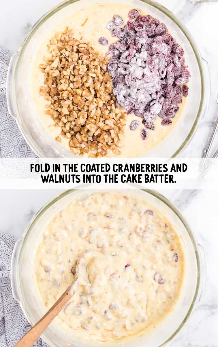 cranberries and walnuts being folded into a bowl of cake batter