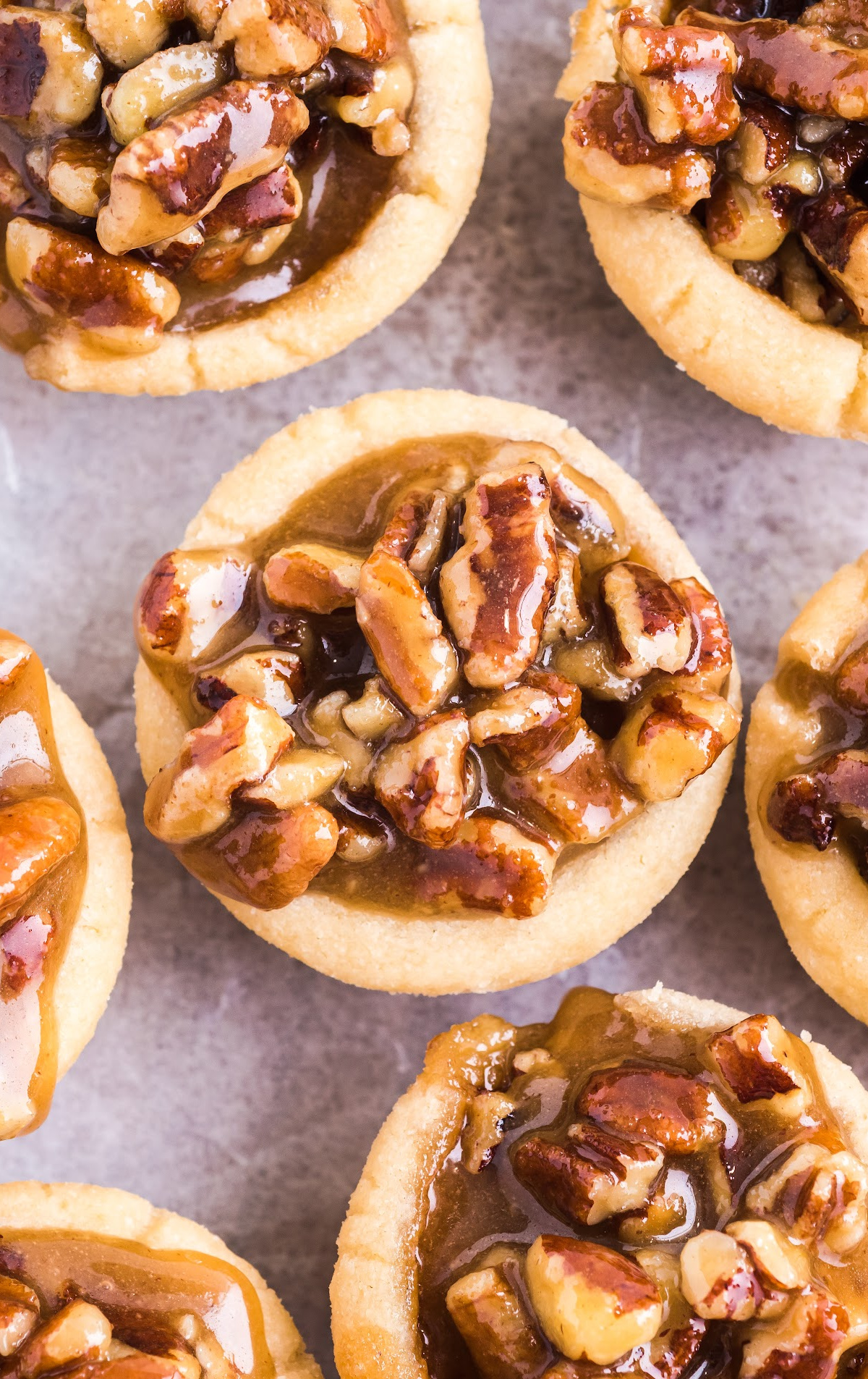 an overhead shot of pecan pie bites on a piece of white parchment.