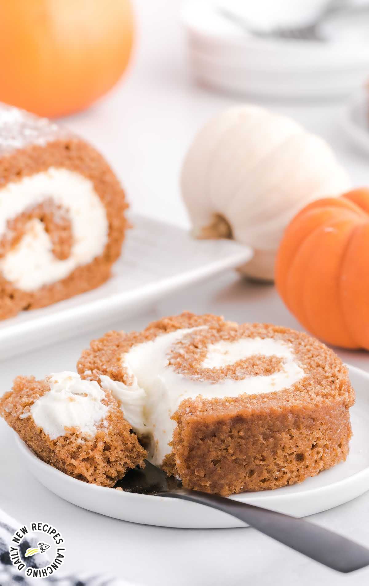 close up shot of a slice of Pumpkin Roll on a plate with a fork