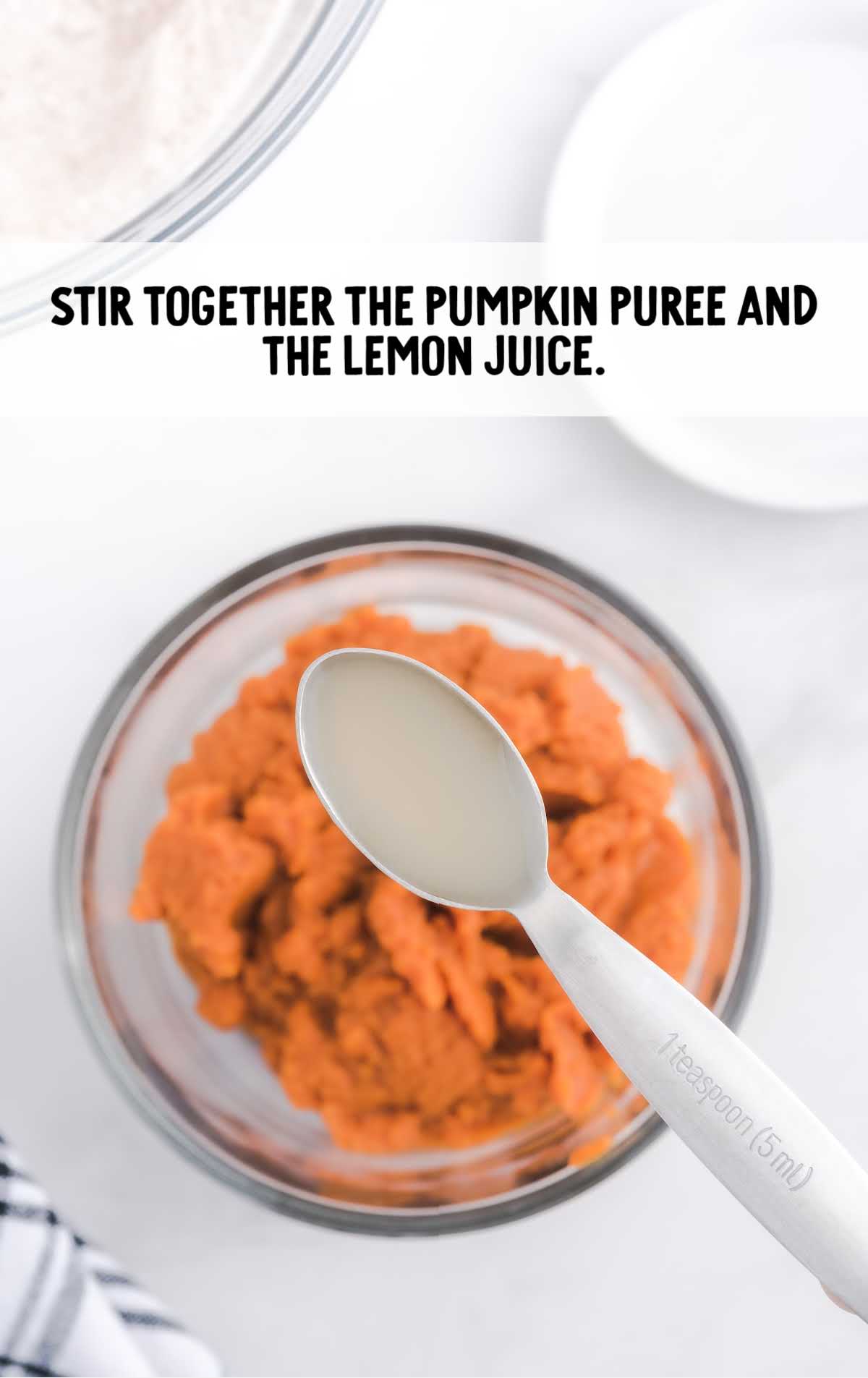 Pumpkin Roll process shot of lemon juice being added to a bowl of pumpkin puree