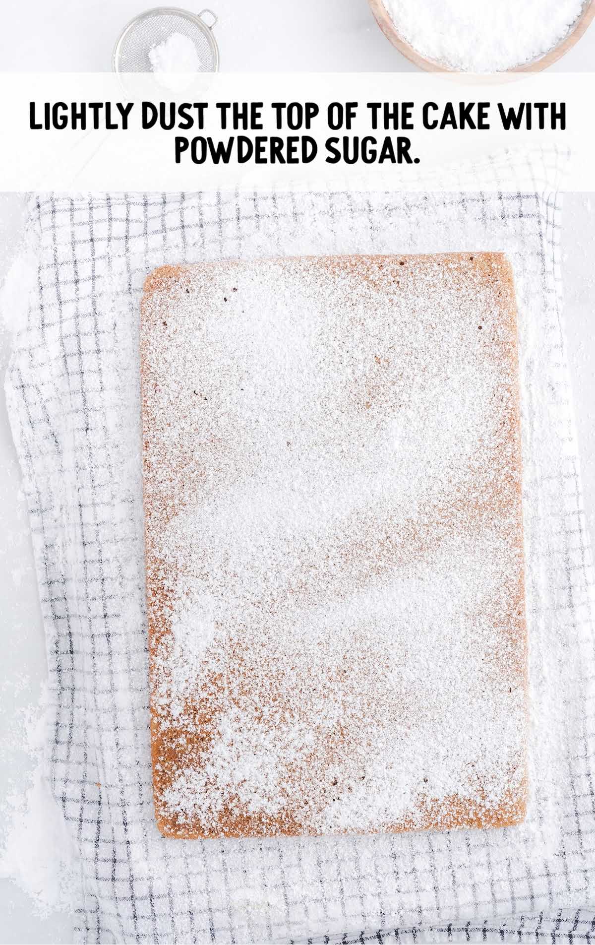 Pumpkin Roll process shot of powdered sugar being dusted on the top of the cake