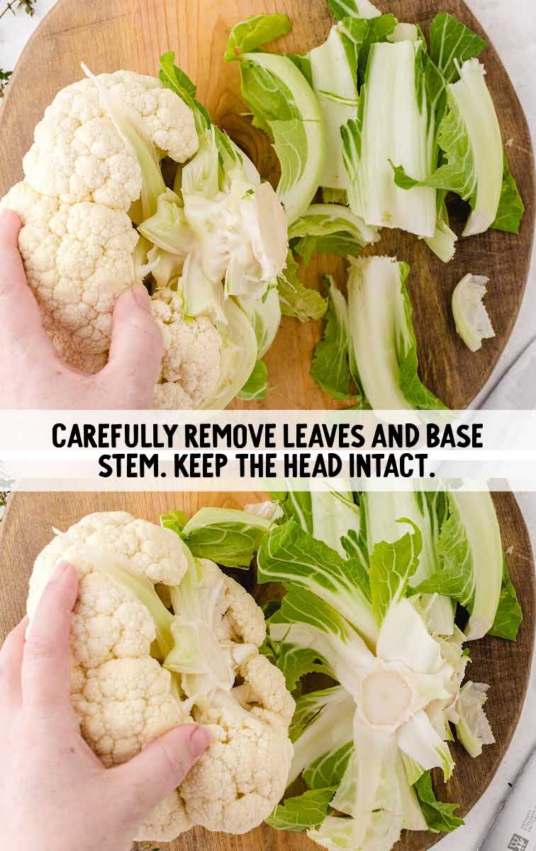 Roasted Cauliflower process shot of leaves and base stem being removed from the head of a cauliflower on a wooden board