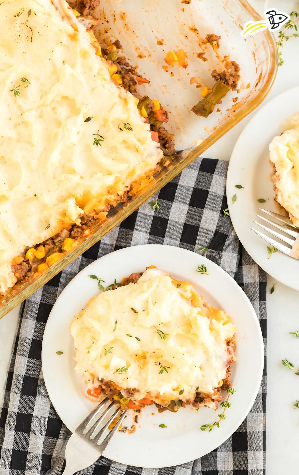 overhead shot of a slice of Shepherd's Pie on a plate and Shepherd's Pie in a baking dish