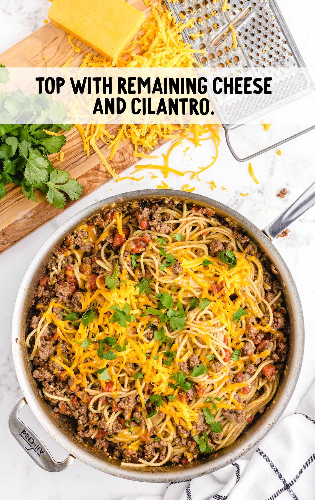 spaghetti topped with shredded cheese and cilantro
