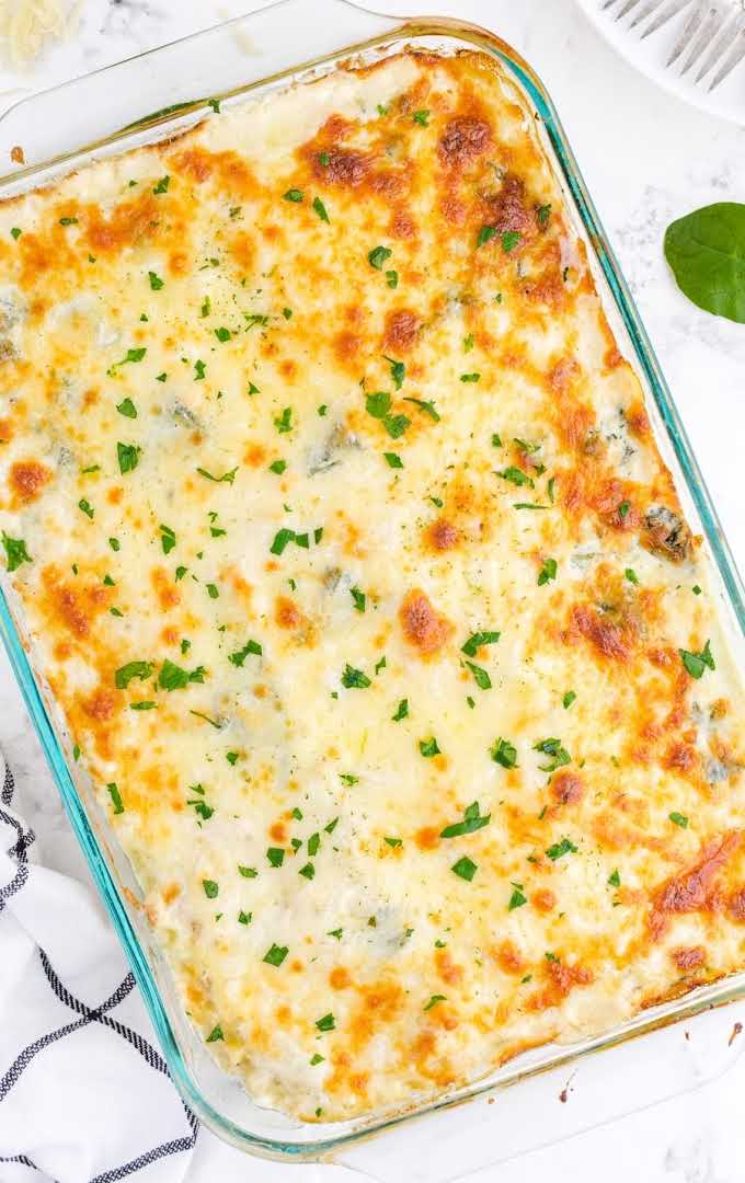 close up overhead shot White chicken lasagna garnished with parsley in a baking dish